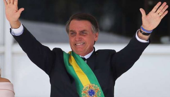 NA FOTO - Com a faixa presidencial que recebeu de Michel Temer, Jair Bolsonaro acena para a multidão em Brasília (Foto: Reprodução)